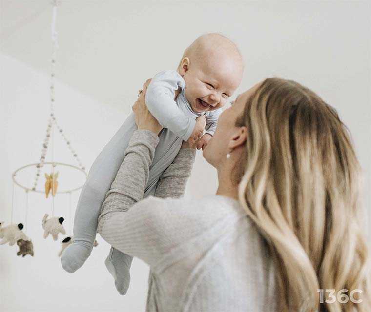 Leben mit ITP: Eine Mutter hält ihr lachendes Baby hoch